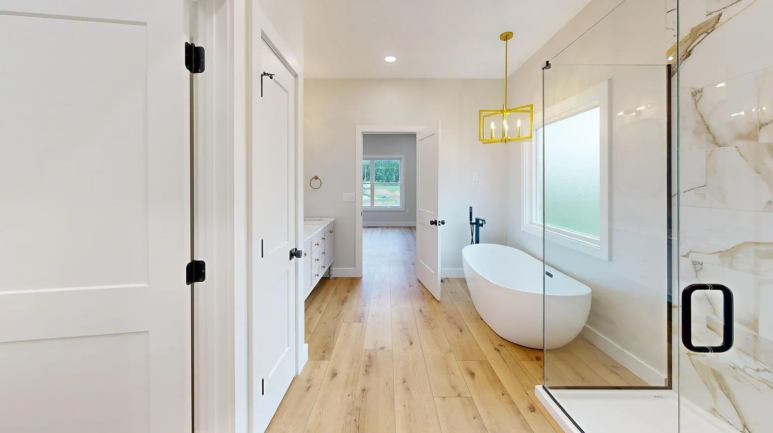 Navy Lane Bright bathroom with a freestanding tub and glass shower