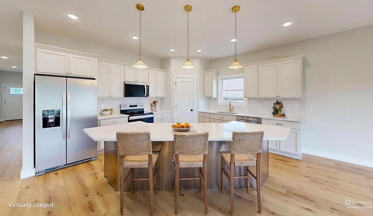 Navy Lane Virtually staged kitchen with white cabinets, island seating, and brass pendant lights